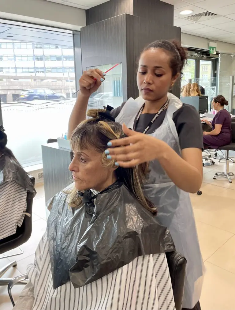 Students learning to style hair in salon